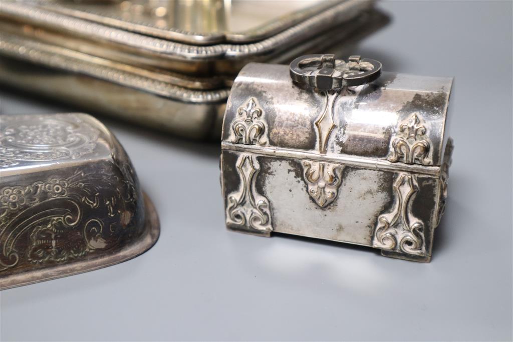 A pair of silver plated entree dishes with covers and handles, a plated butter dish, two condiments, a small vase and a trinket box